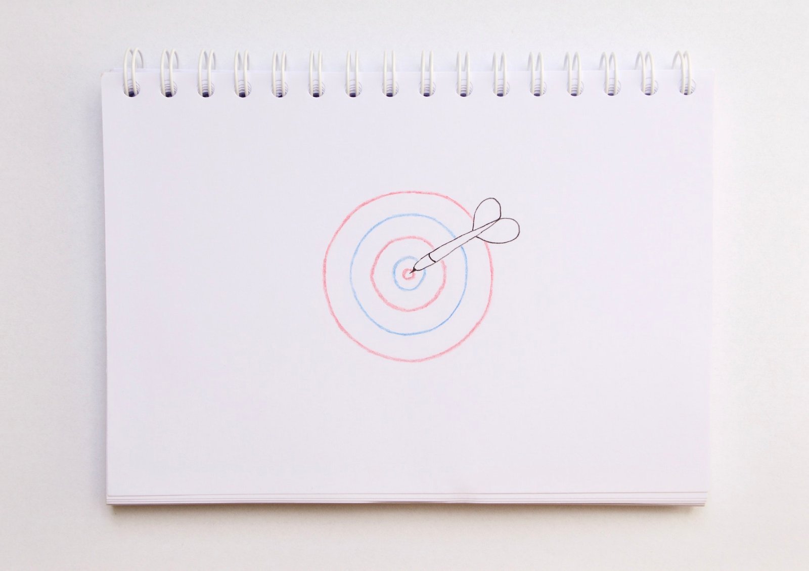 Overhead photo of a notebook with drawing of a target, goal or aim to reach achievement in business